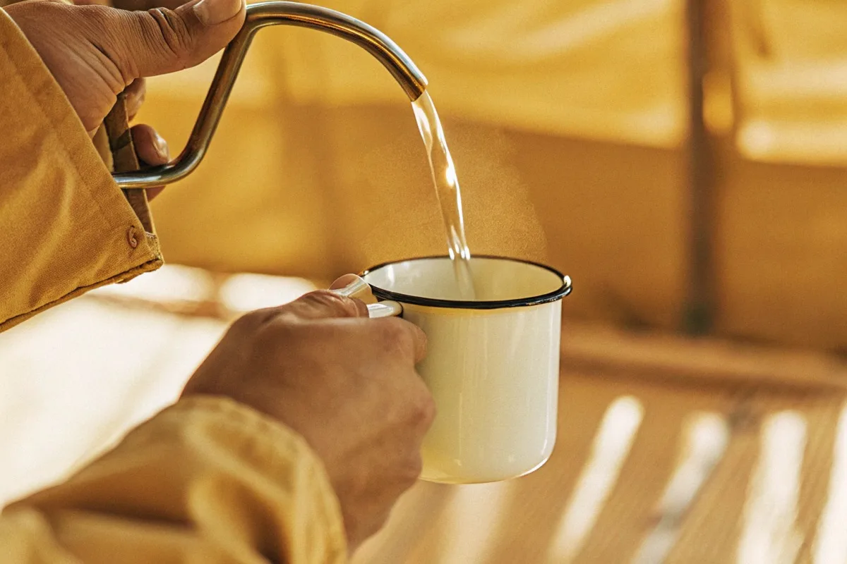 Evaluating grip comfort and balance of an enamel mug sample before bulk ordering (ID#2)